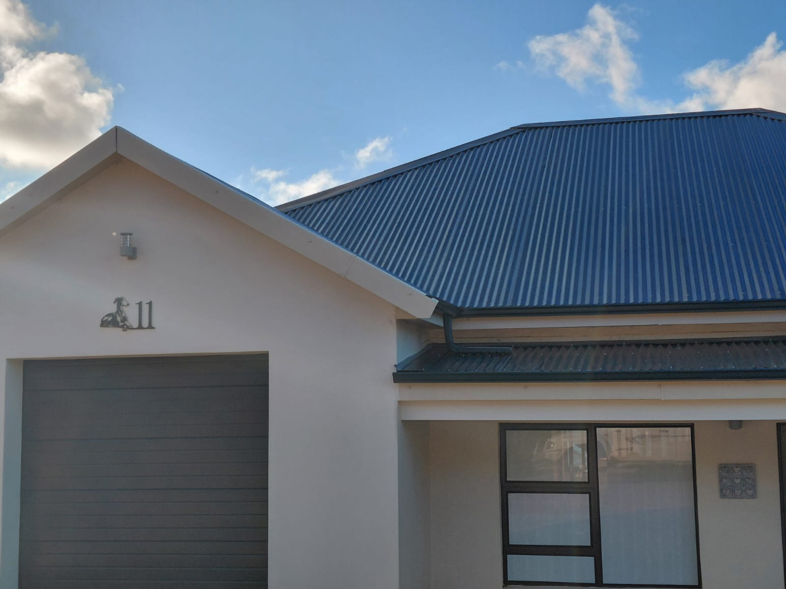 Modern white house with distinctive blue metal roof
