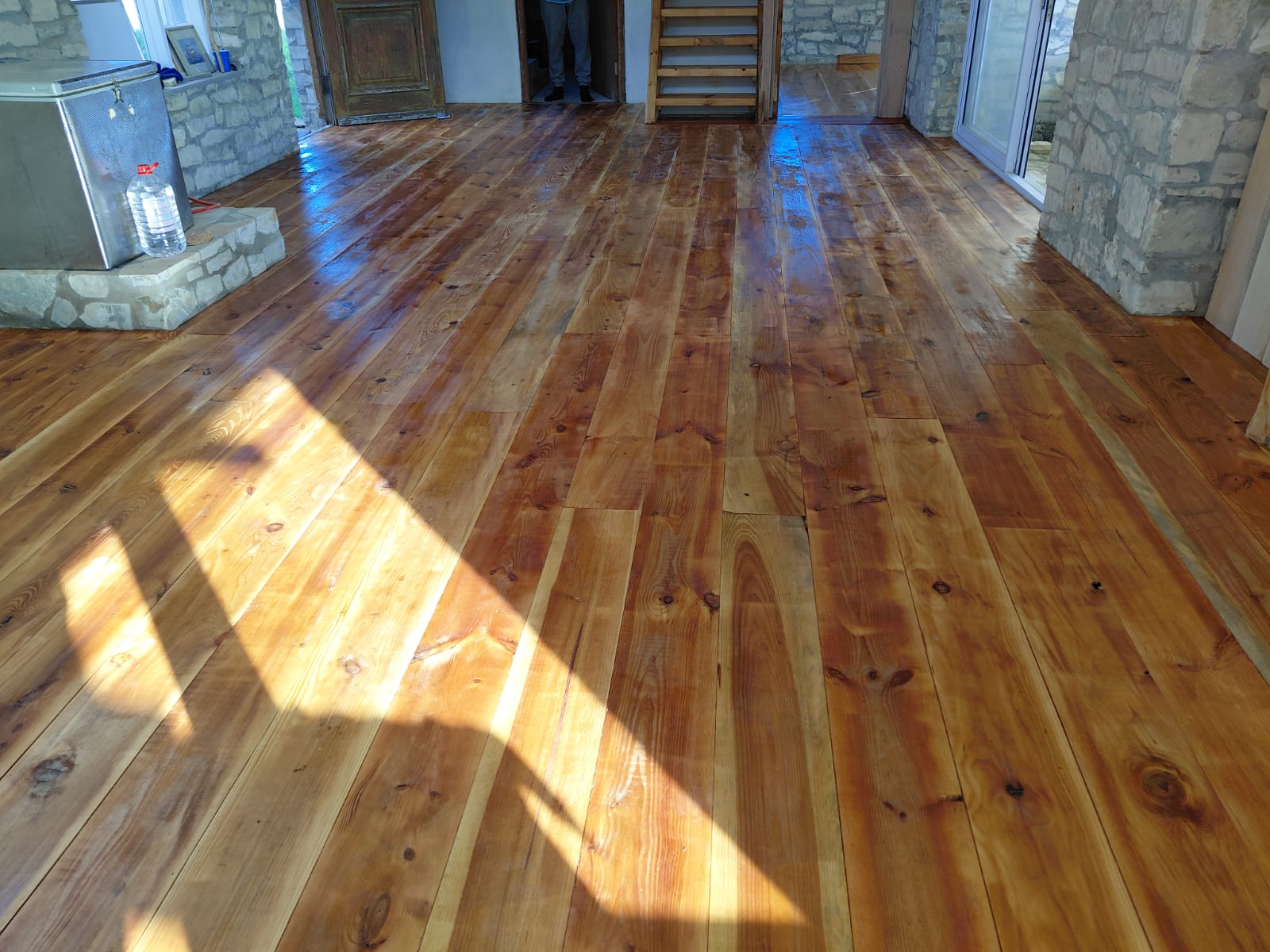 Spacious interior with newly installed hardwood flooring and stone walls
