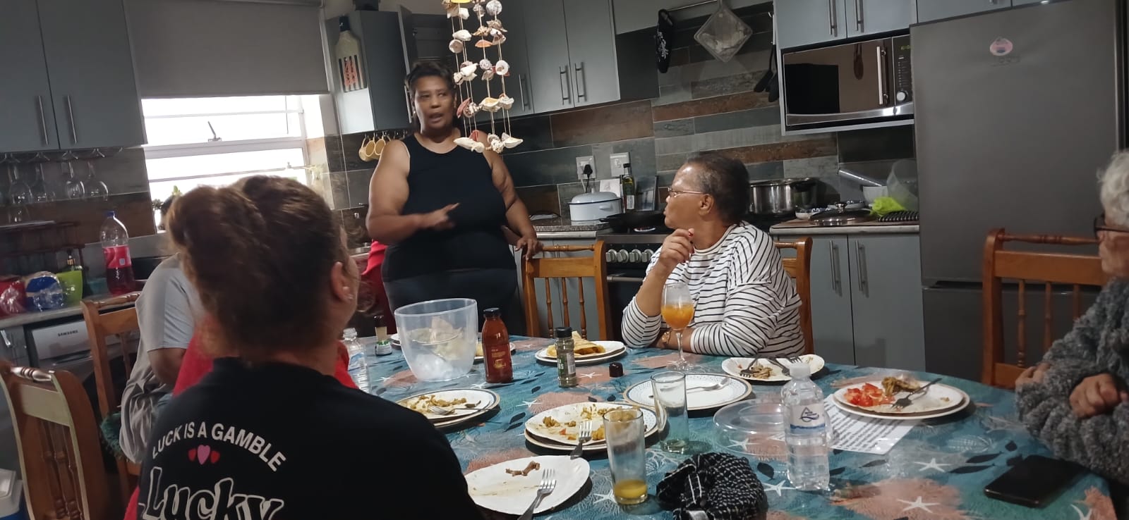 Group sharing a meal around the kitchen table during Ladies' Camp