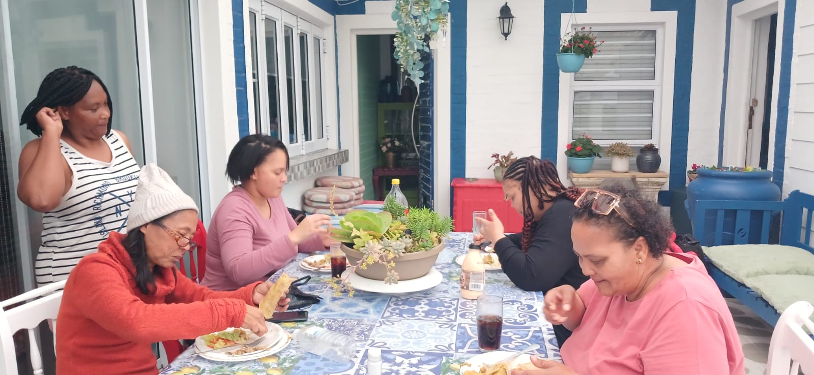 Family enjoying a meal on the blue and white patio during Ladies' Camp