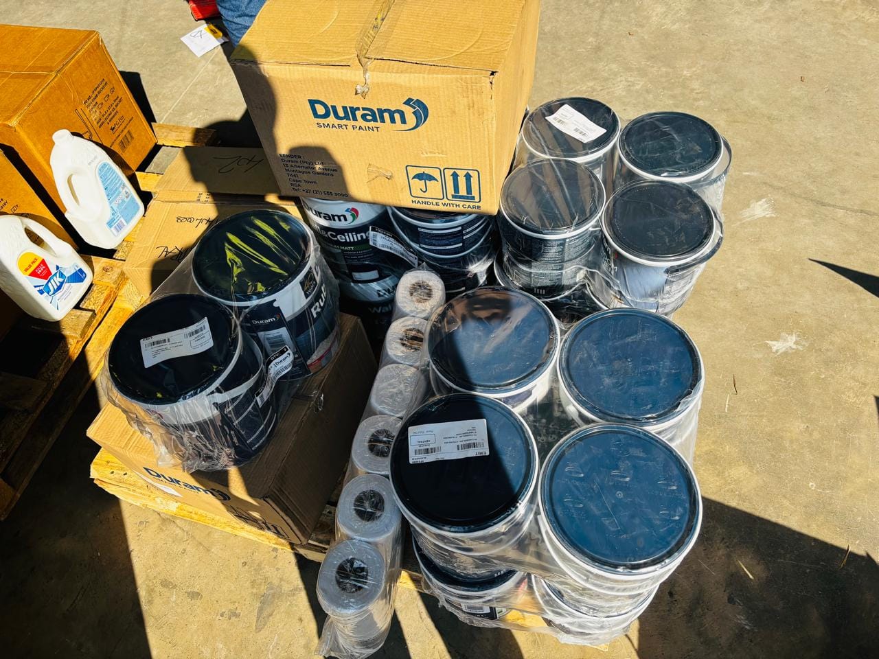 Overhead view of Duram Smart Paint cans and boxes arranged on the ground for supply