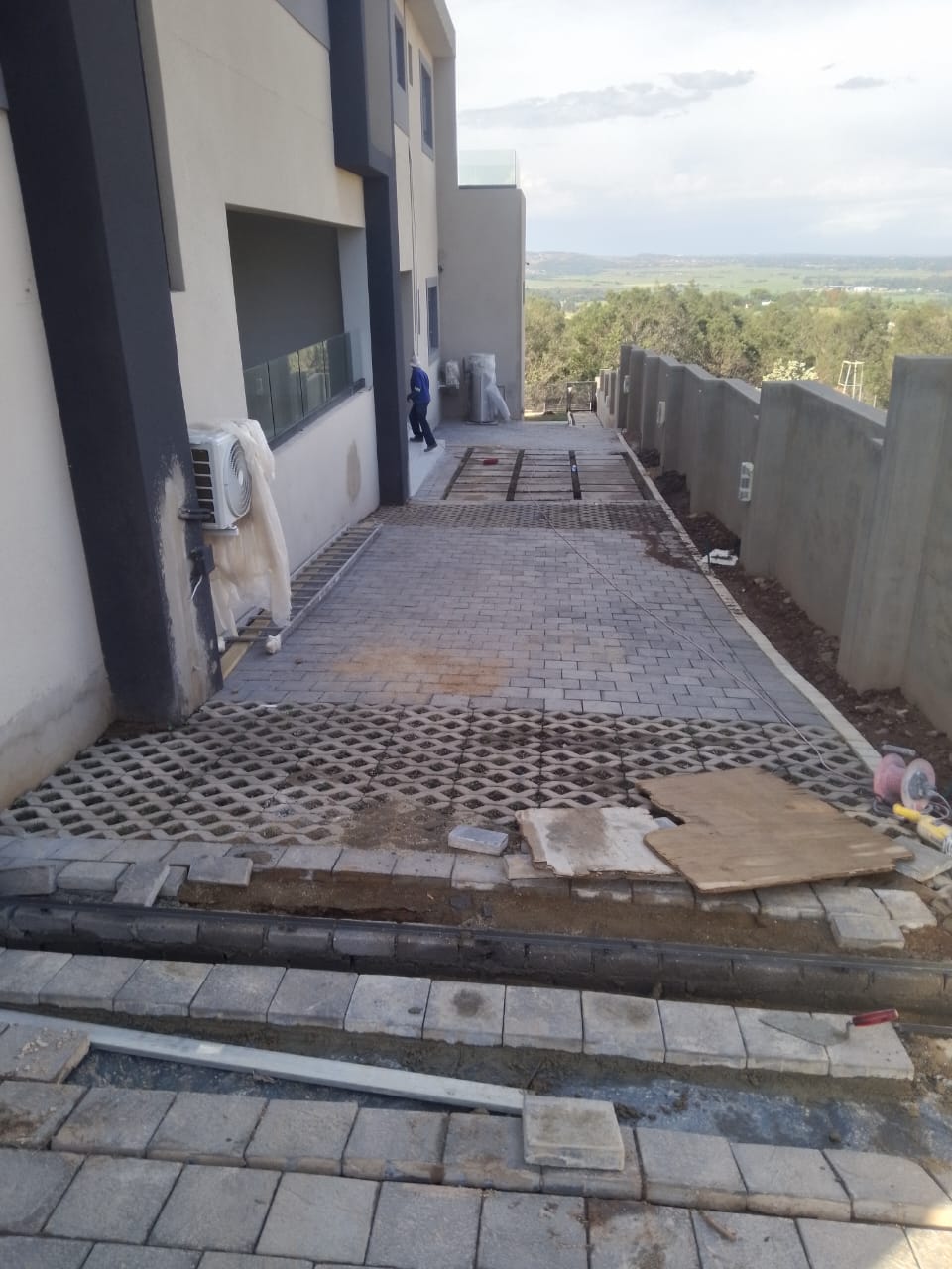 Modern house under construction with paved driveway and countryside view
