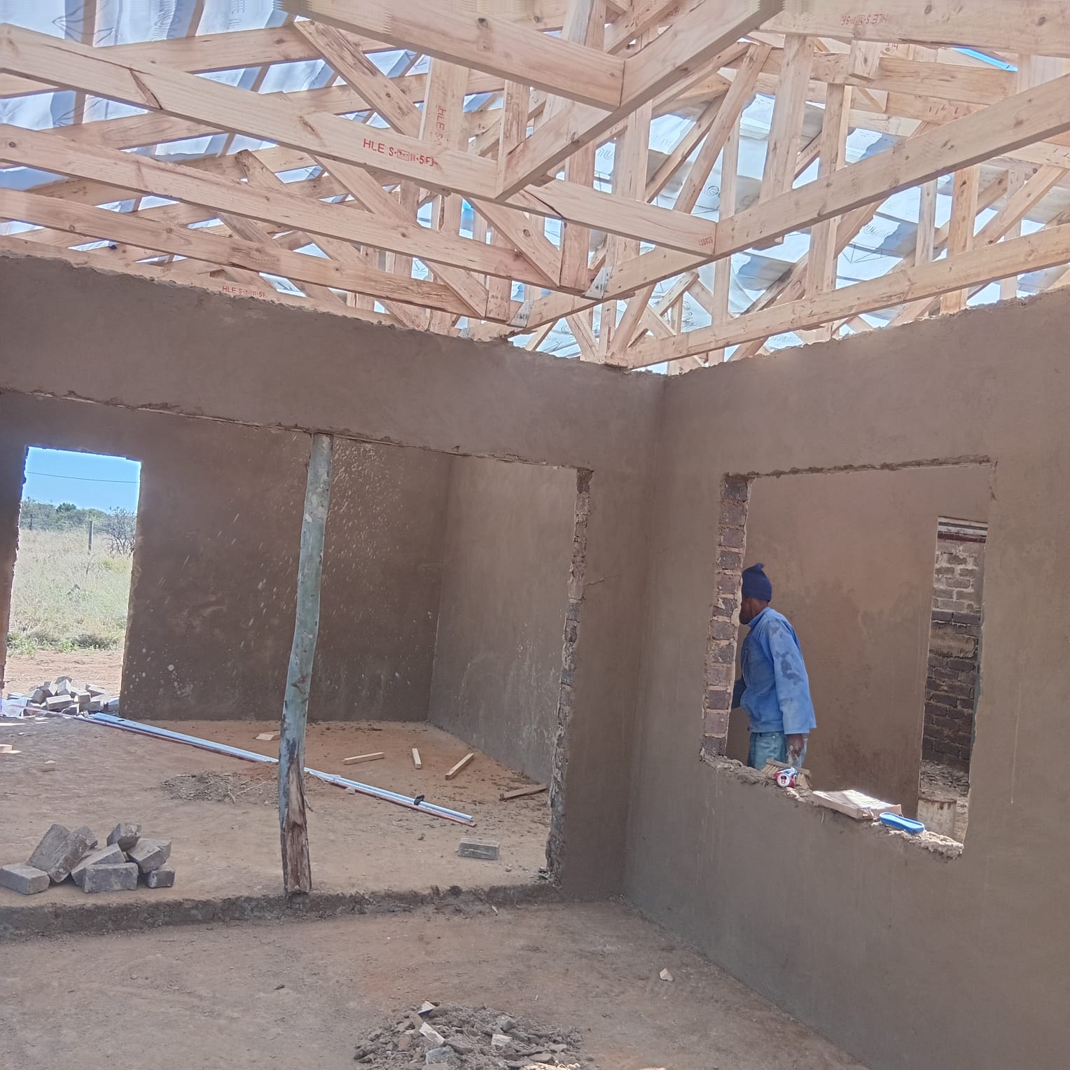 Construction worker inside unfinished building with concrete walls