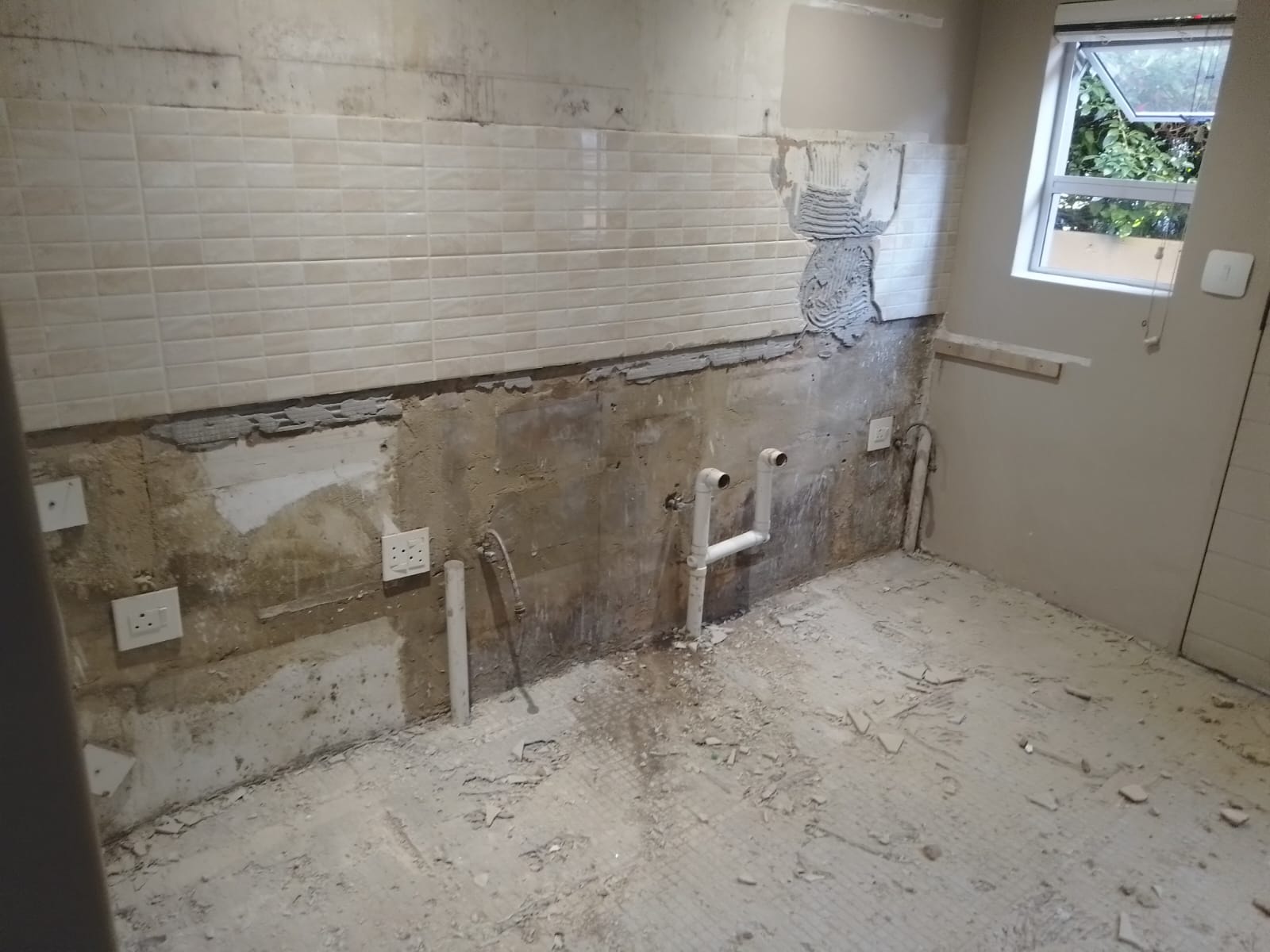 Bathroom under renovation with partially tiled walls