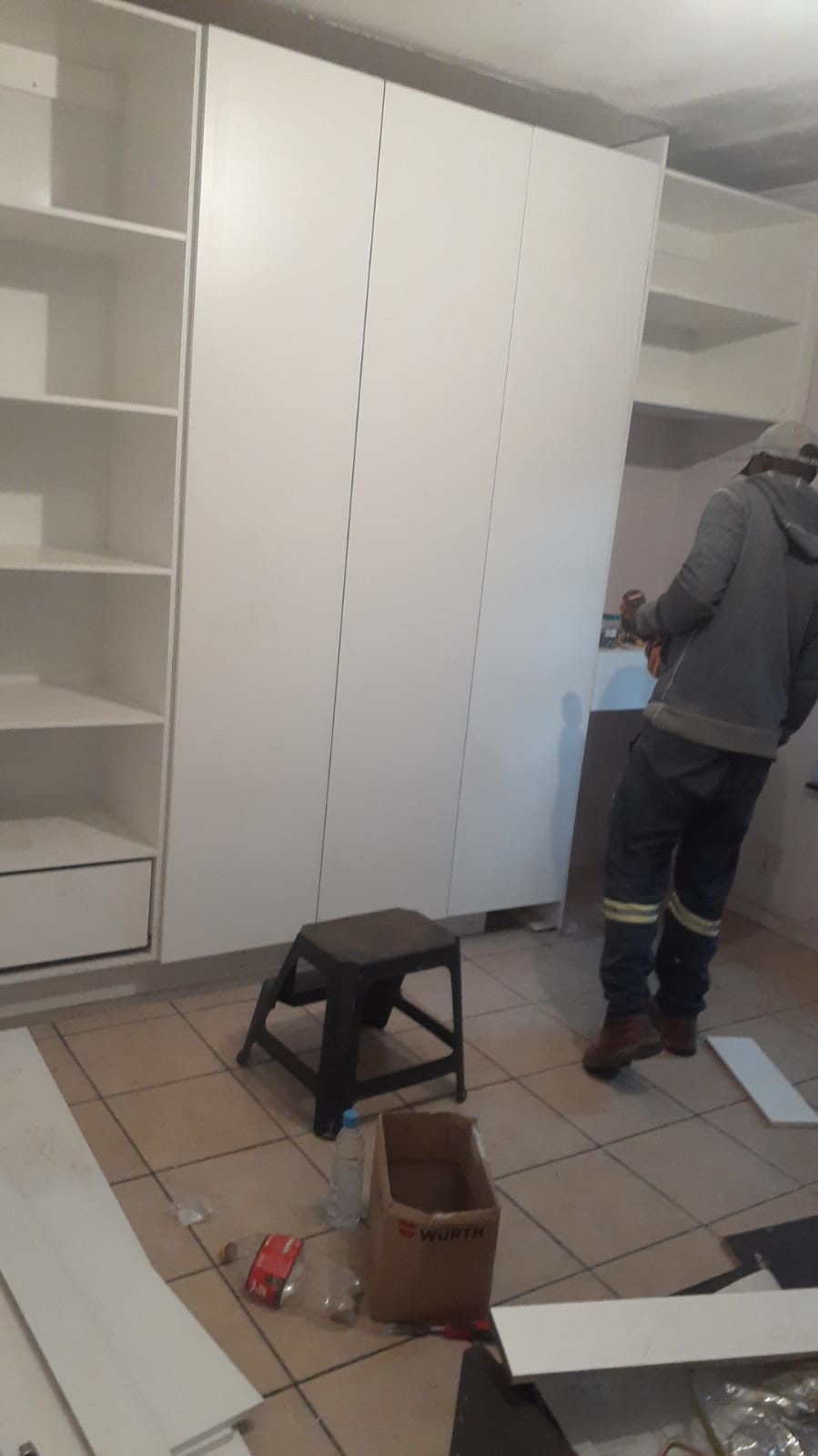 White wardrobe installation with builder on site