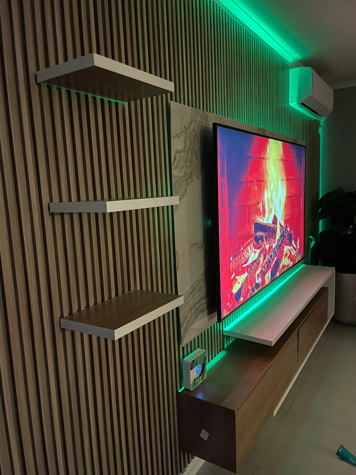 Modern entertainment wall with vertical slats, floating shelves and neon lighting