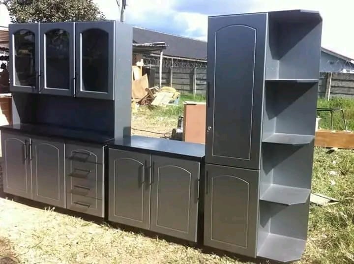 Modern black modular kitchen cabinet system with glass upper cabinets displayed outdoors