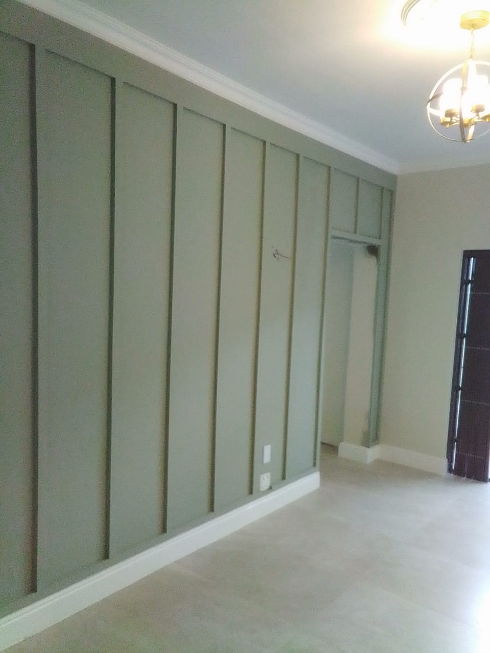 Interior accent wall with sage green shiplap, representing finish craftsmanship
