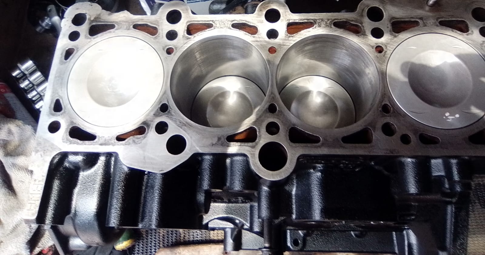 Four-cylinder engine head with pistons and cylinders showing internal components