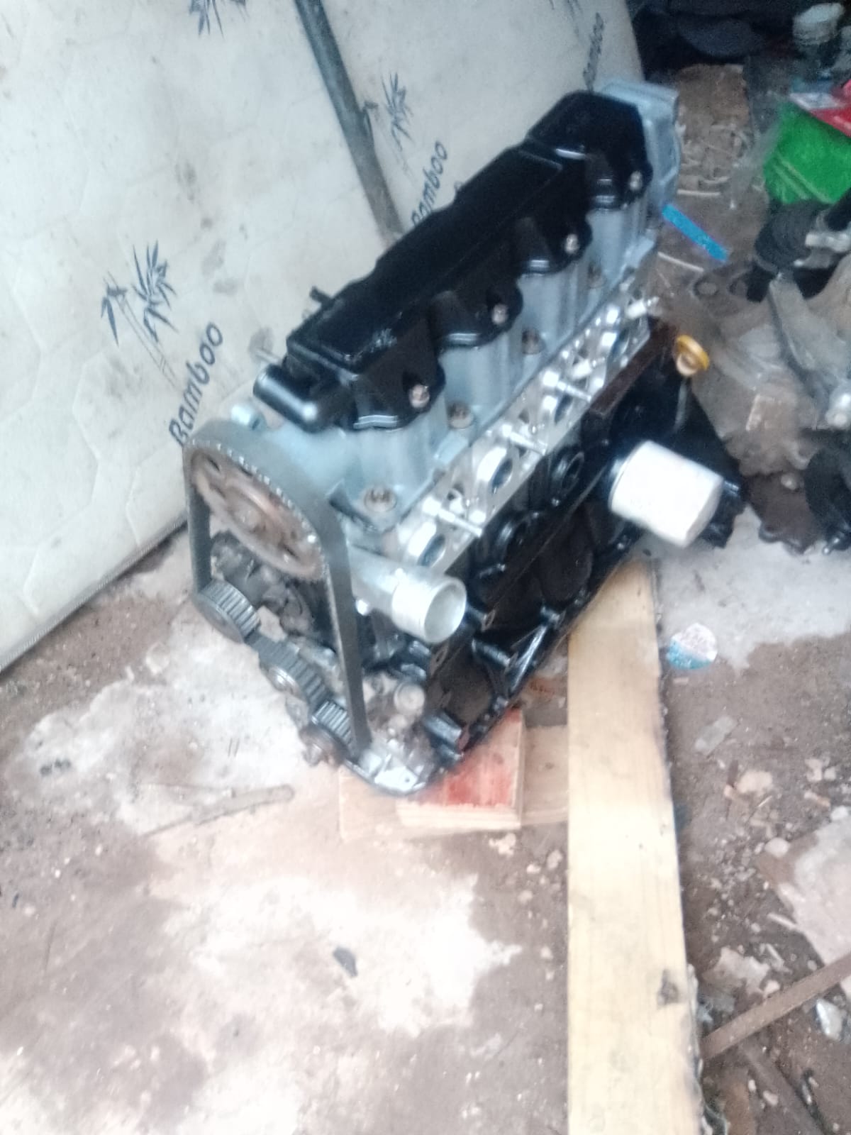 Car engine block with cylinder head and intake manifold displayed on the ground