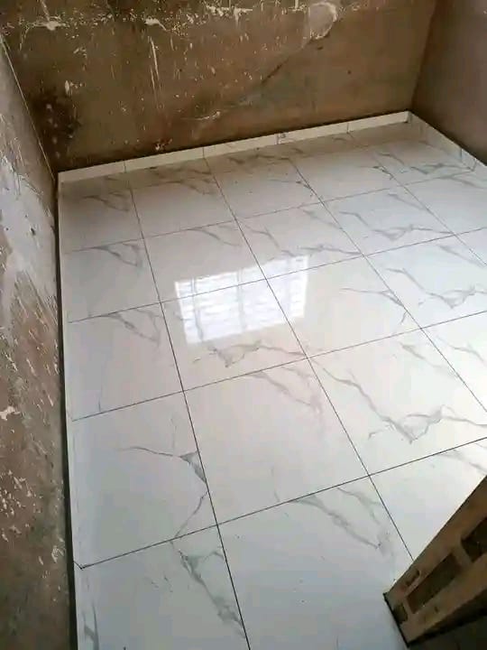 Newly installed white marble-look tile floor with gray veining in a room