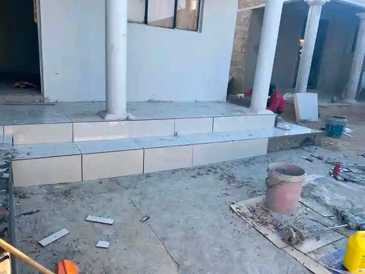 Under-construction interior space with concrete floor and white drywall panels
