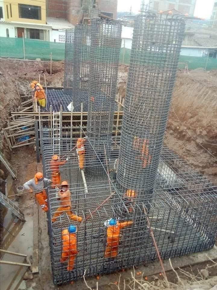 Construction workers assembling reinforced steel rebar cages