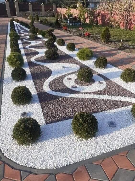 Modern landscaped courtyard with boxwood shrubs and decorative gravel