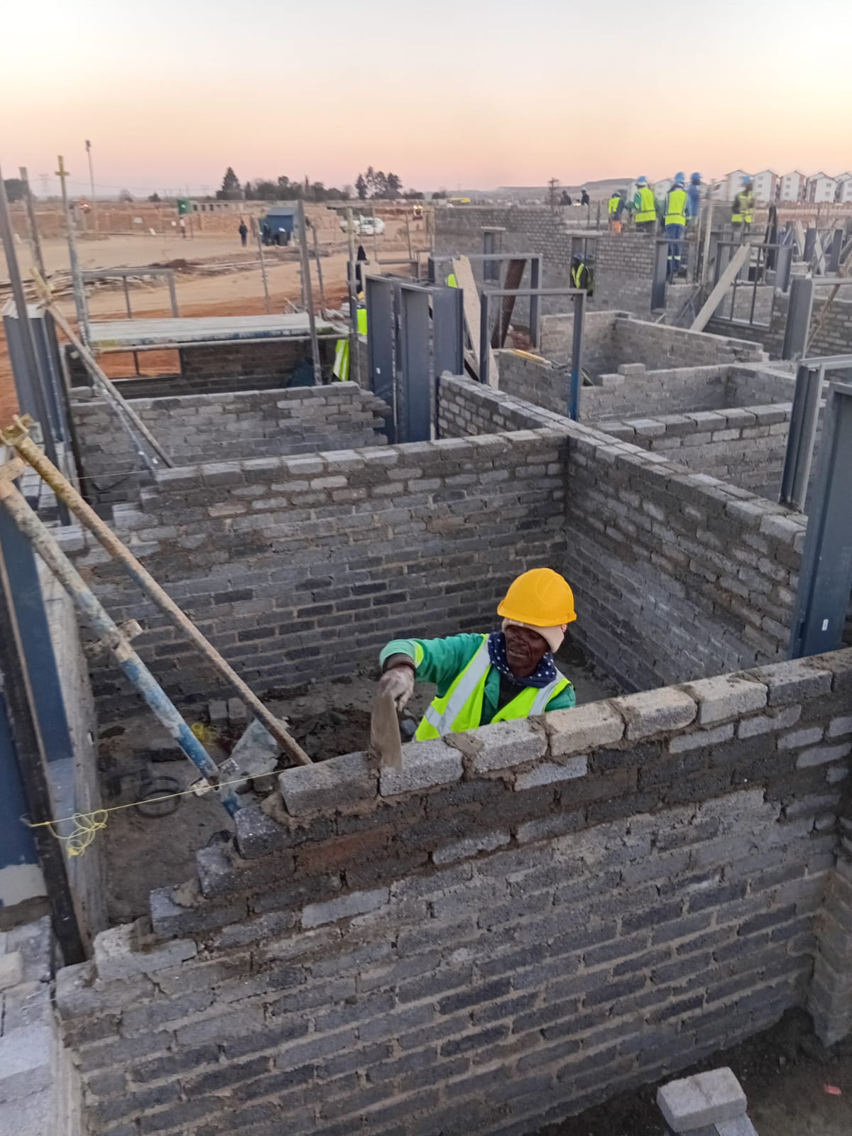 Construction worker laying bricks on a residential development site