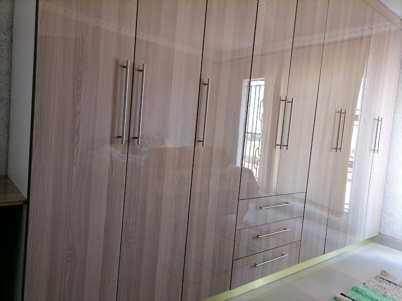 Large bedroom wardrobe with multiple doors and drawers spanning the wall
