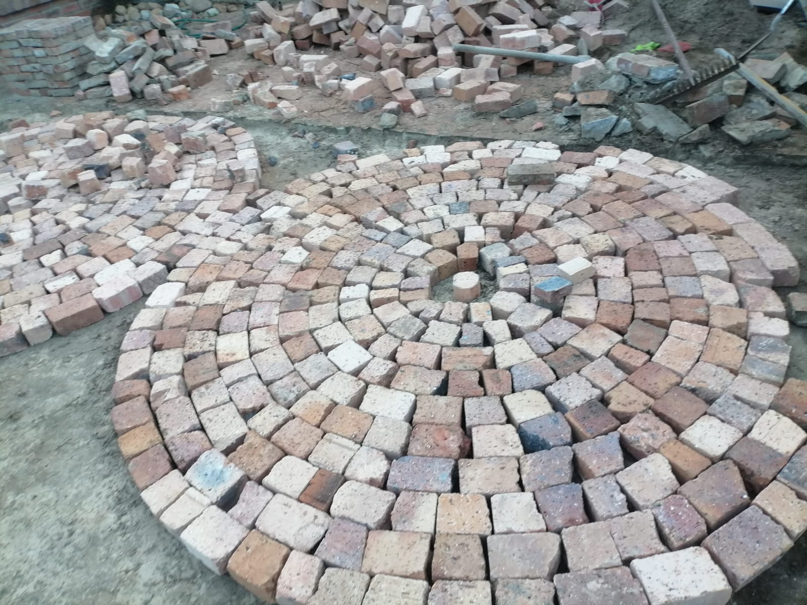 Circular arrangement of terracotta and concrete pavers