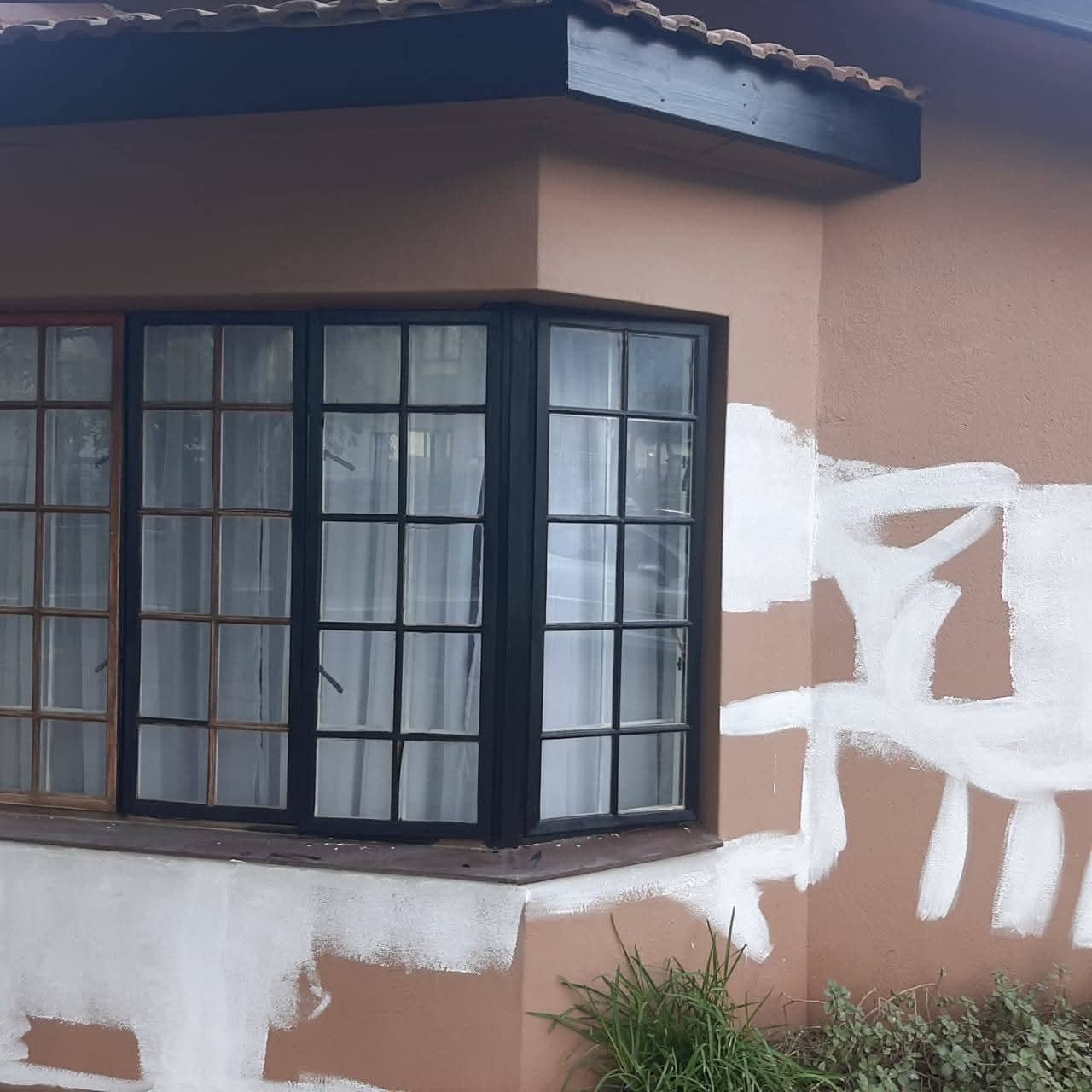 Corner storefront with beige stucco walls and black-framed windows