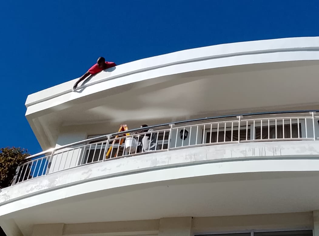 Curved white roof edge of a modern building under clear blue sky