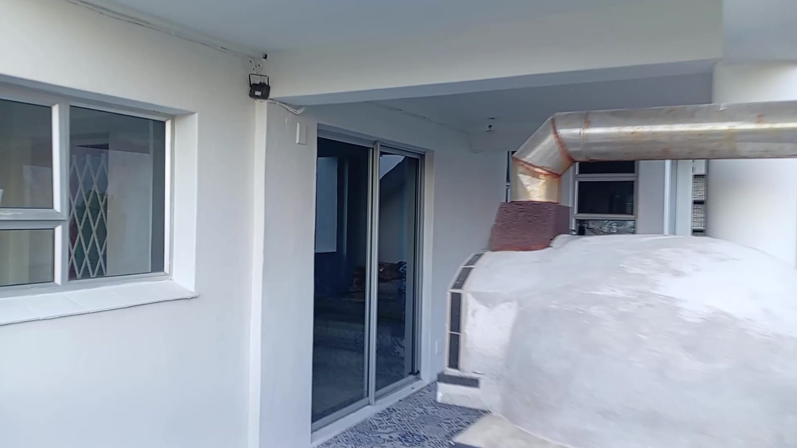Rooftop construction area with white walls and metal ductwork