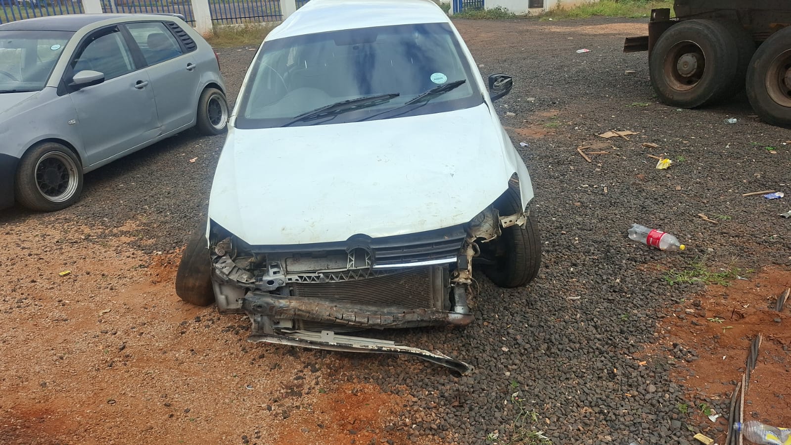 White Renault sedan with severe front-end damage showing destroyed front bumper