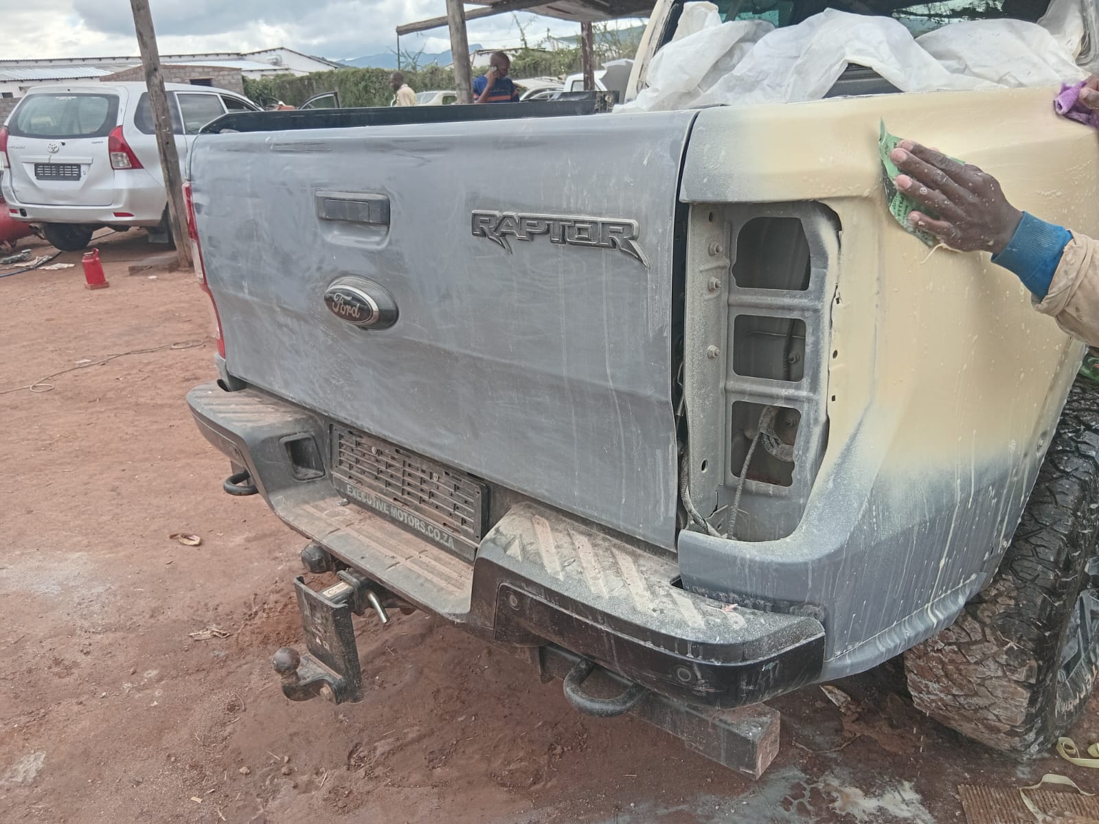 Ford Raptor pickup truck being worked on with protective coating application at repair shop