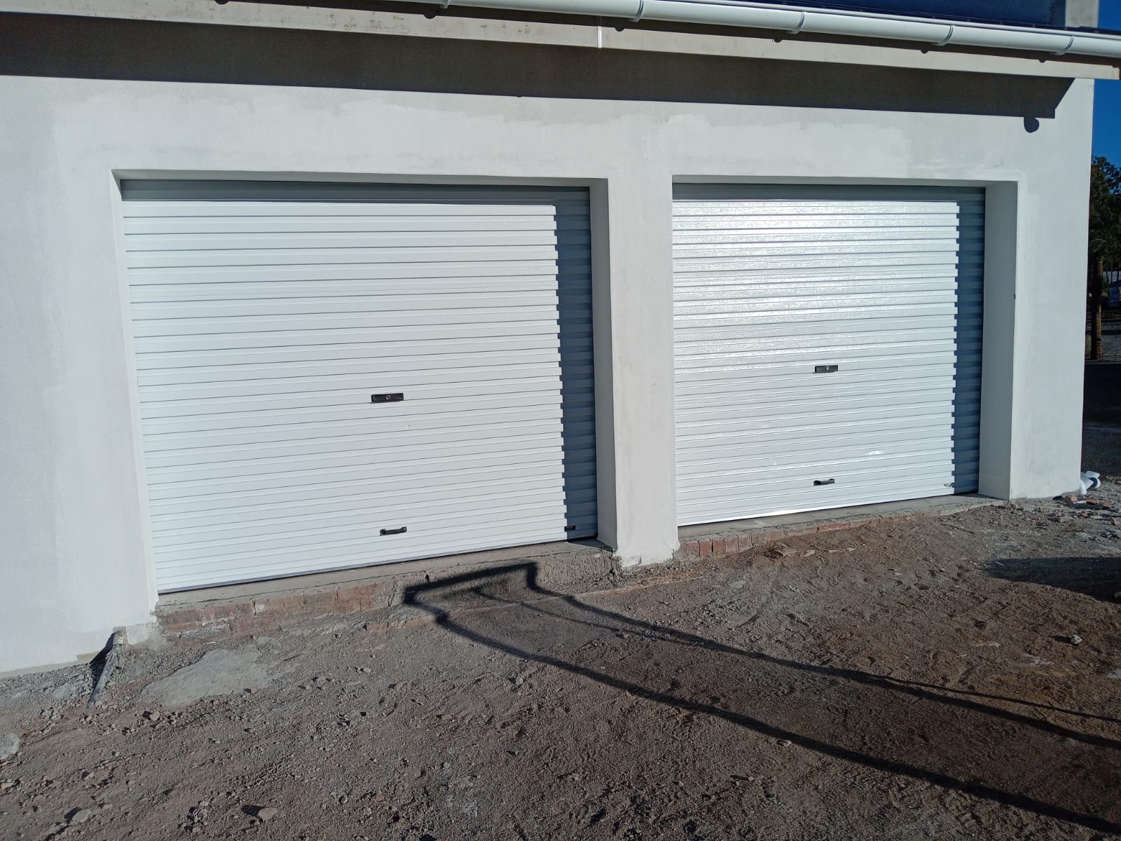 Modern white house with roller shutter garage doors
