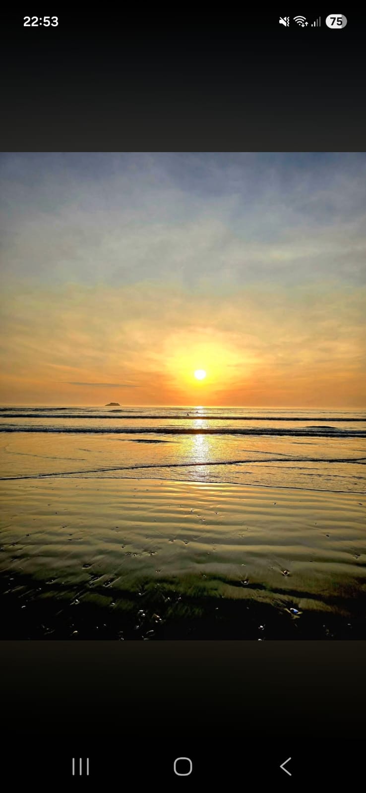 Golden sunset over a calm Yzerfontein beach with gentle waves rolling onto wet sand