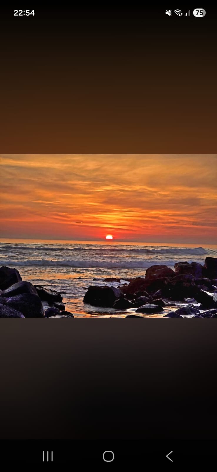 Vibrant sunset over the ocean in Yzerfontein with rocky formations in the foreground