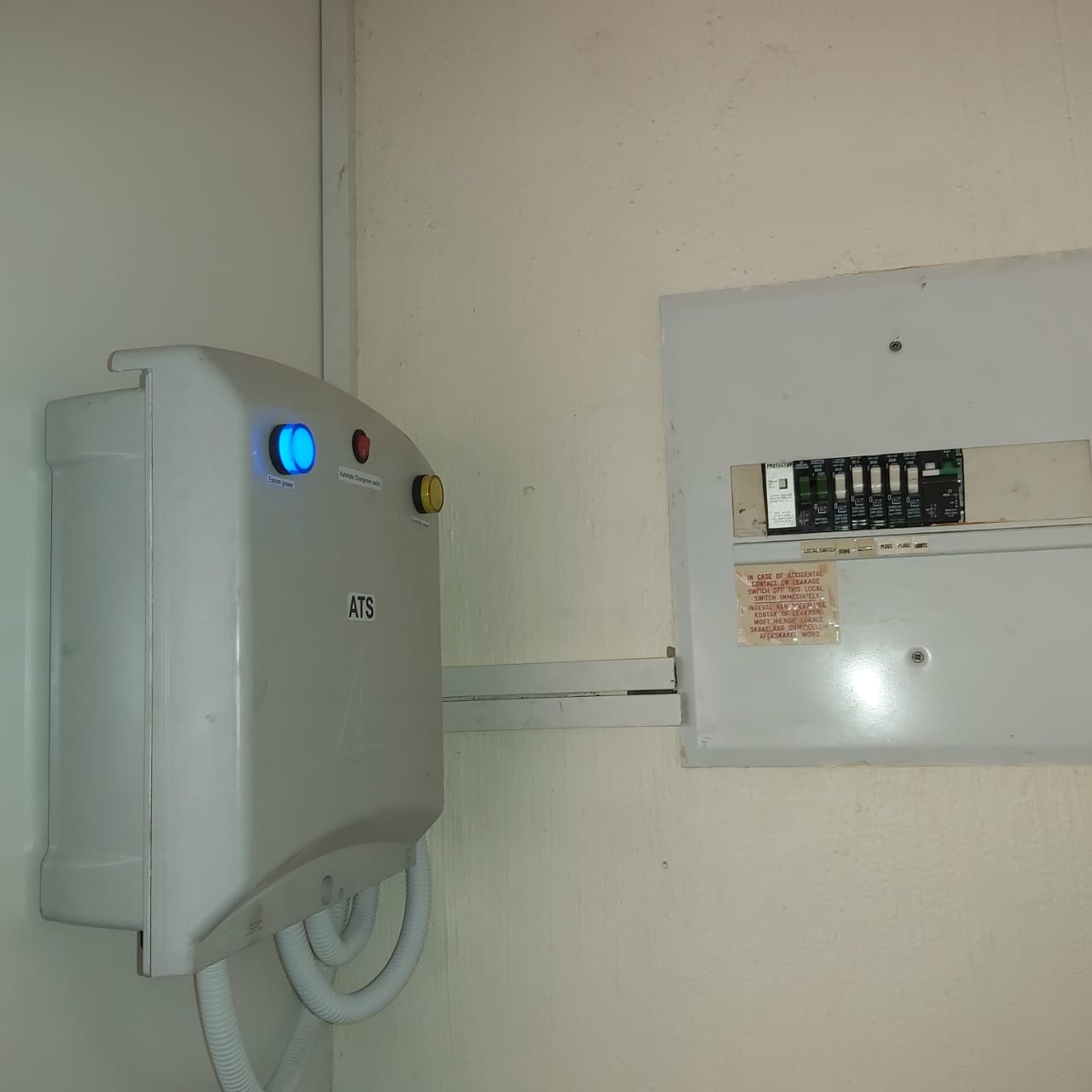 ATS unit with blue illuminated indicator light mounted on wall