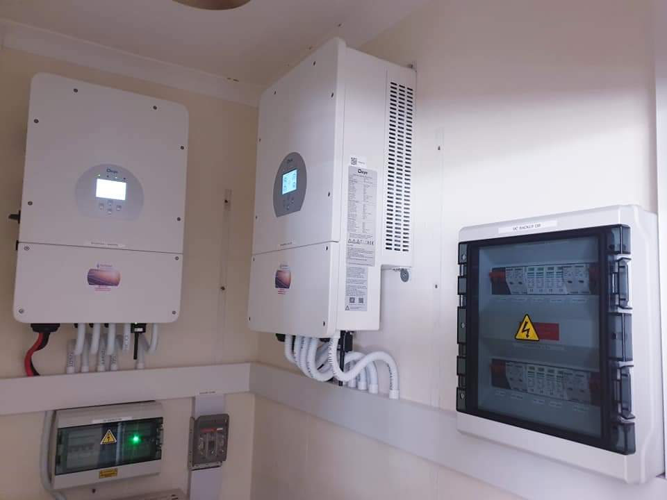 Wall-mounted solar power system with multiple white inverters and monitoring displays