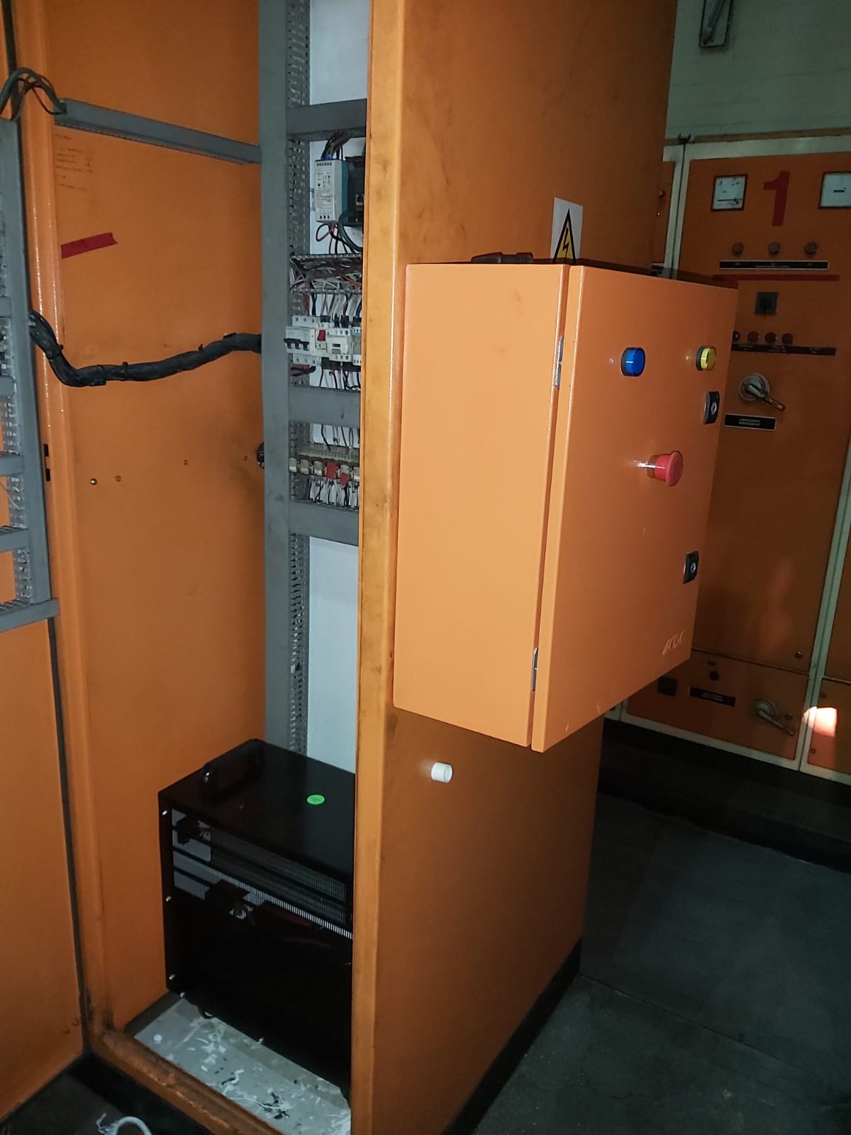 Industrial electrical control panel room with bright orange metal enclosures