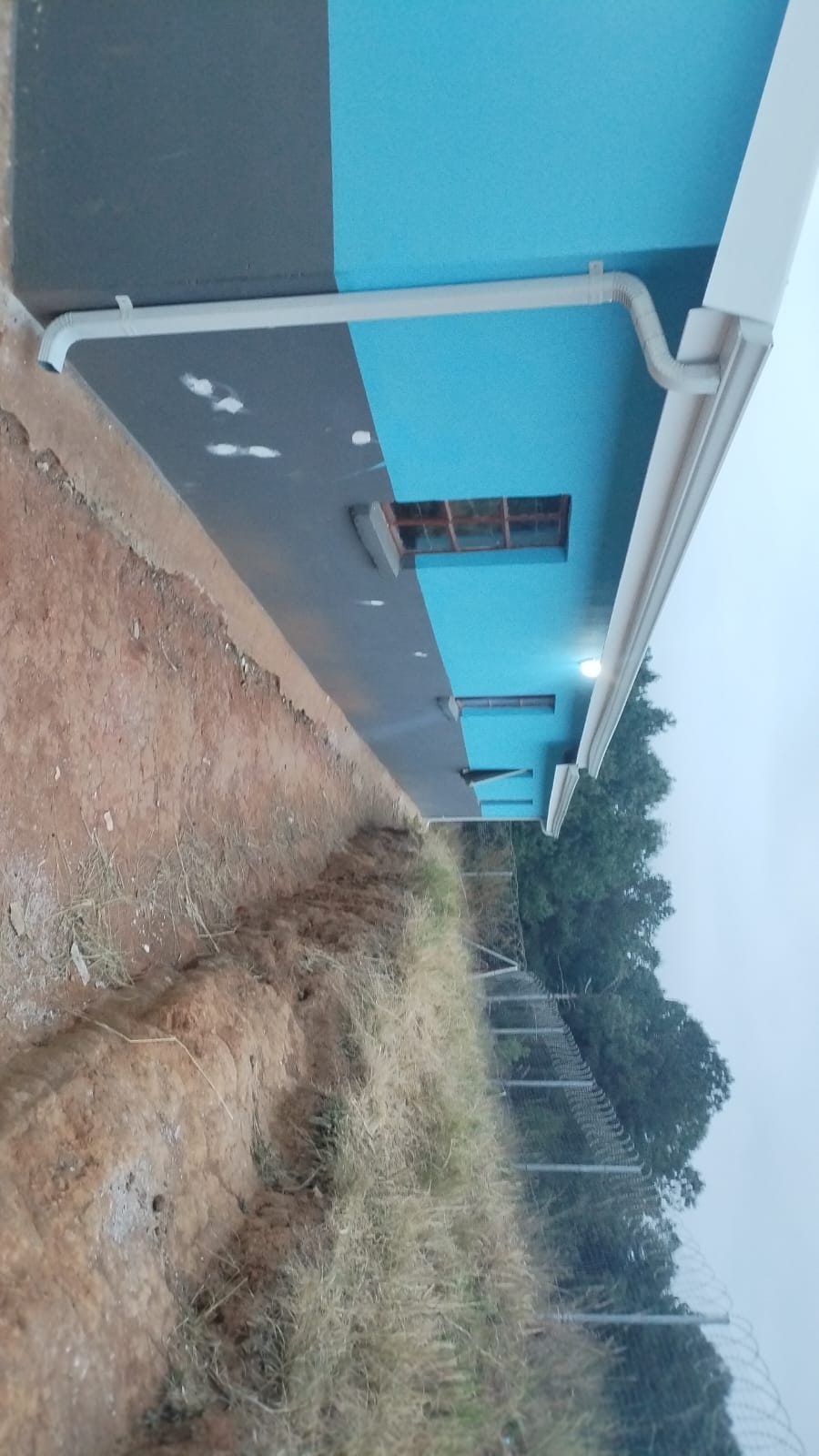 Modern building with blue roof and brick wall alongside