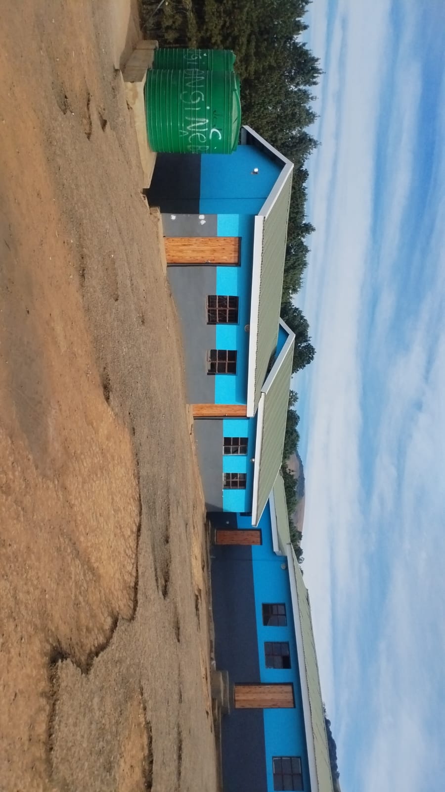 Blue and black residential building with water tank on top