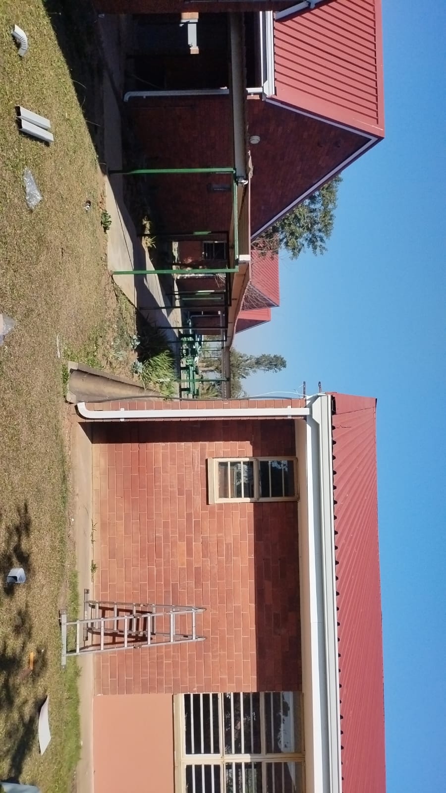 Two story brick house with red metal roof