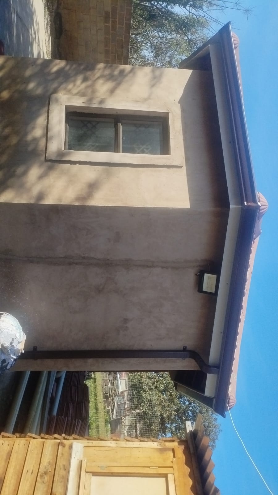 Two story cream residential building with blue metal side panel