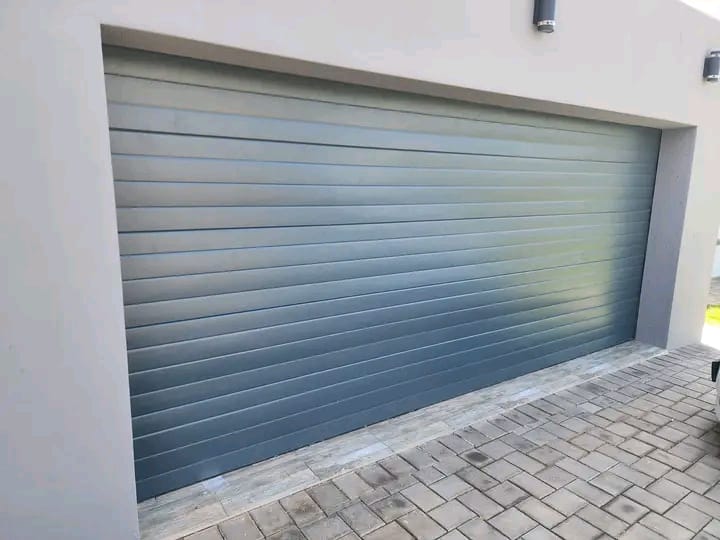 Modern gray horizontal roller garage door installed in a residential garage opening