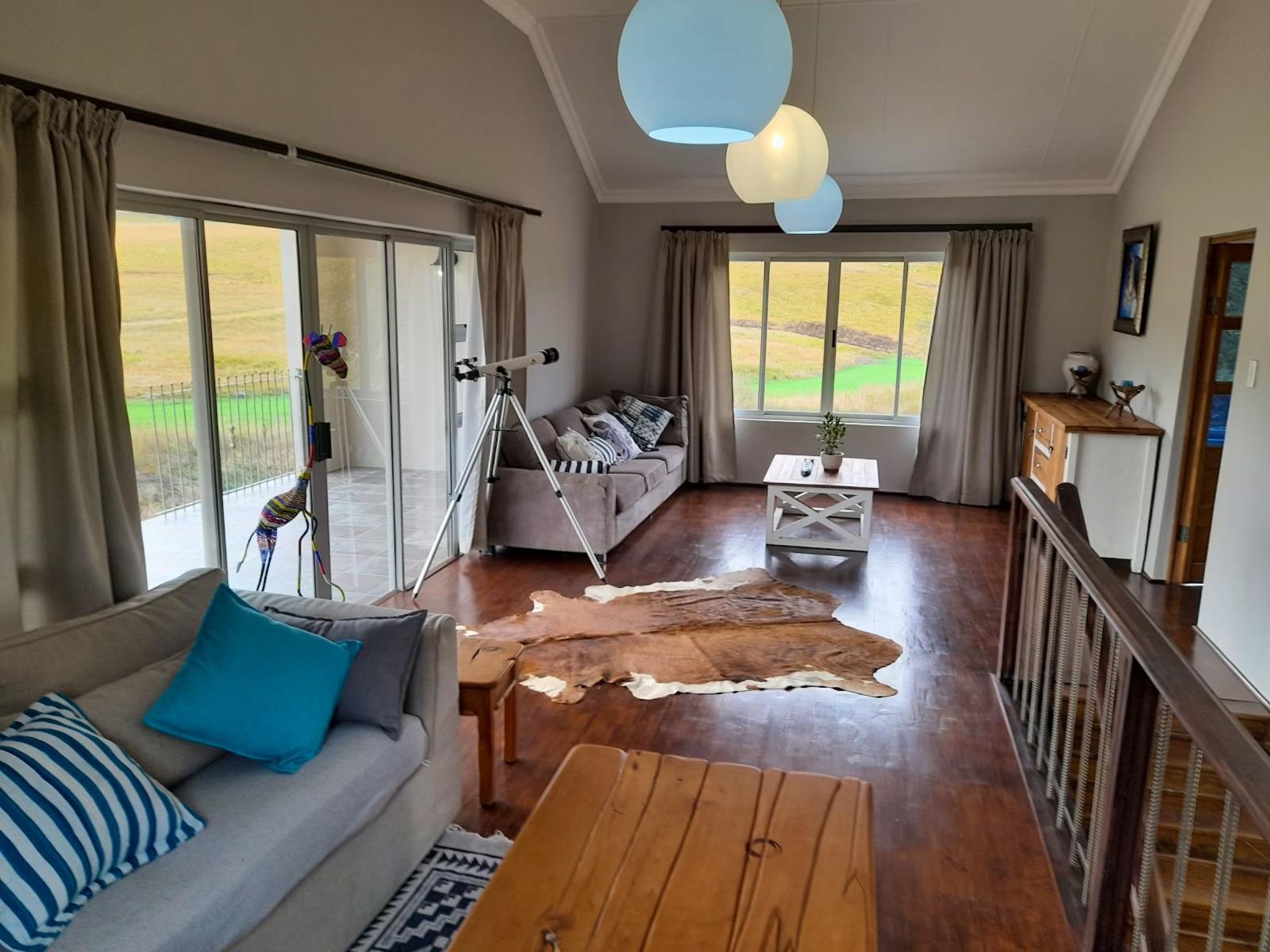 Spacious modern living room with large countryside windows and wooden floors