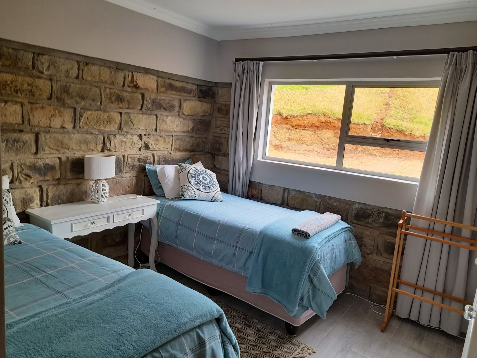 Twin bedroom with stone accent wall and countryside view