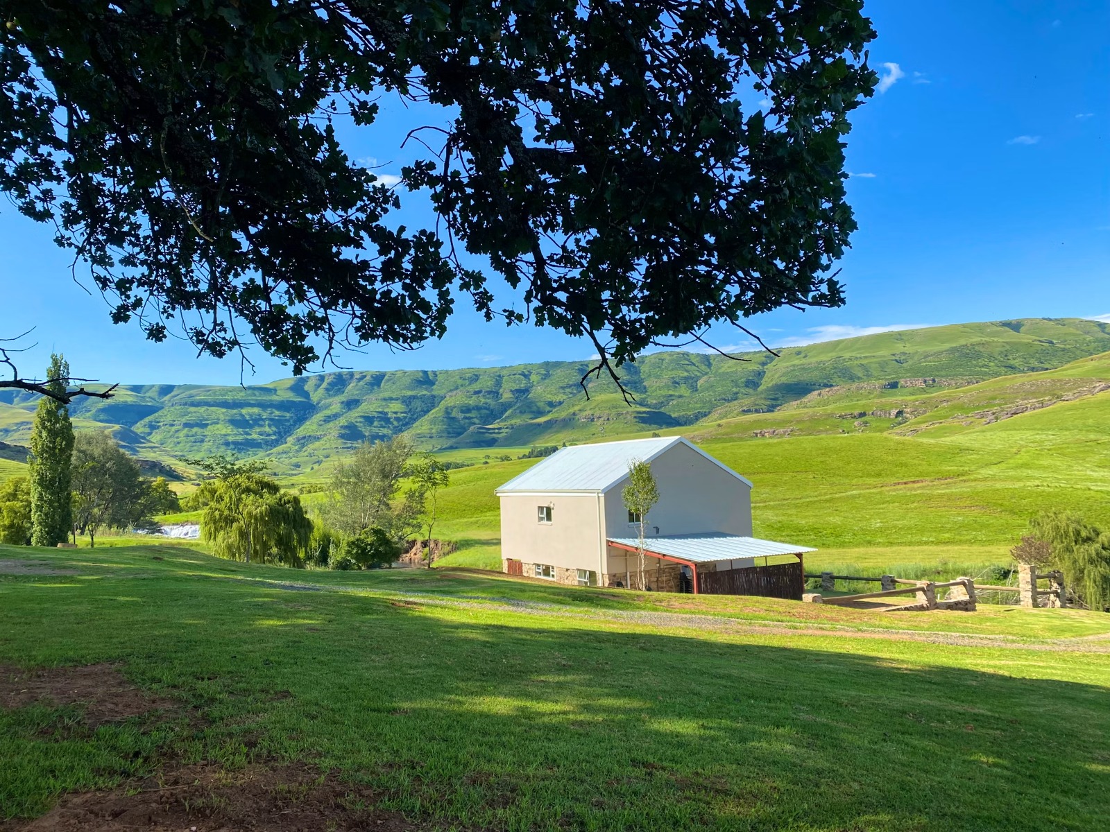 White farmhouse exterior in green valley