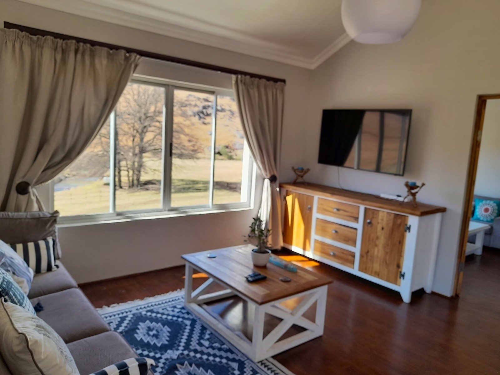 Bright living room with gray sofa and landscape view