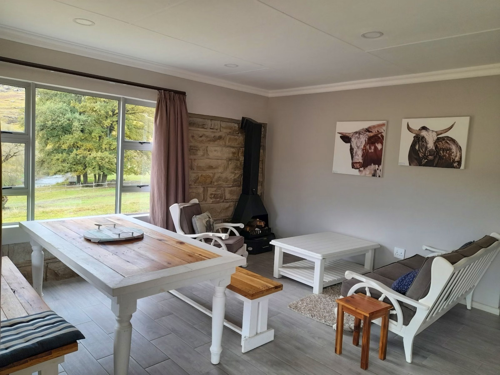 Farmhouse-style living room with wood stove and cattle artwork