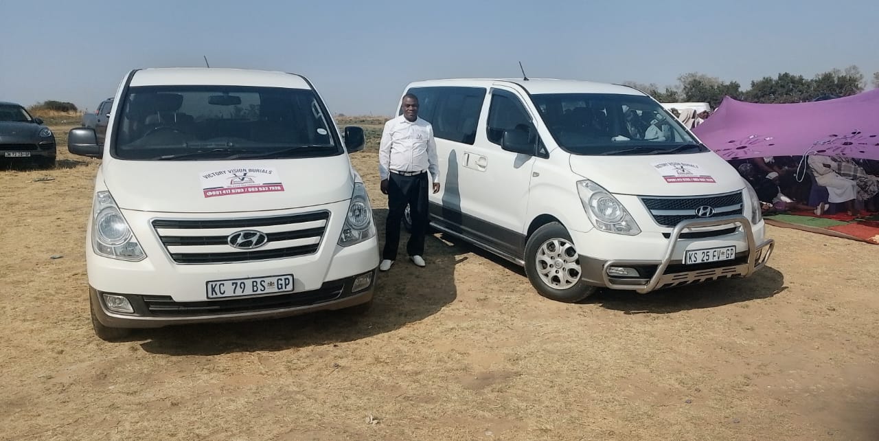 Two white Hyundai minivans at an outdoor event